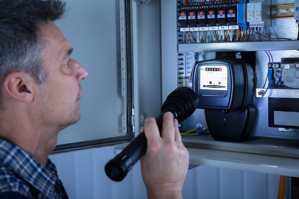 Foto: Close-up,Of,A,Electrician,Examining,A,Fusebox,With,A,Torch, Shutterstock